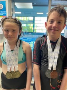 Swimmers Emily & Callum showing off their medals