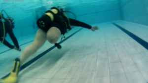 A single leg amputee scuba dives in a swimming pool